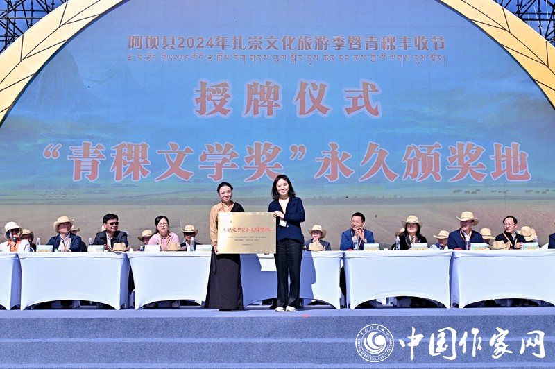 陳亞軍主編代表《民族文學》向阿壩縣授牌，紅梅部長接牌。