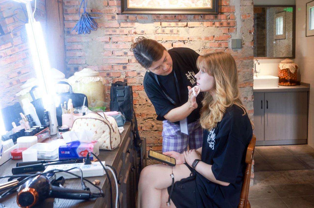 2025年6月30日，百集微短劇《鐘鼓樓前》在北京鼓樓前開機(jī)。圖為俄羅斯籍女演員瑪利亞在開拍前化妝。 中新社記者 賈天勇 攝